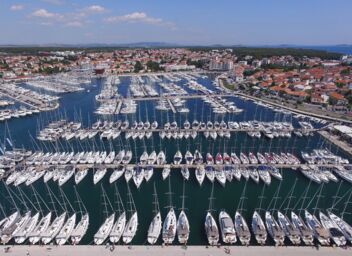 Aerial view of a marina with boats and a seaside promenade