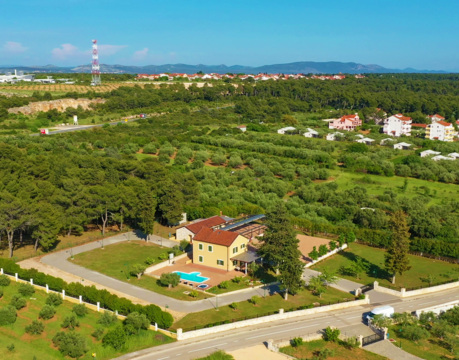 Vista aerea di una casa con piscina circondata dal verde