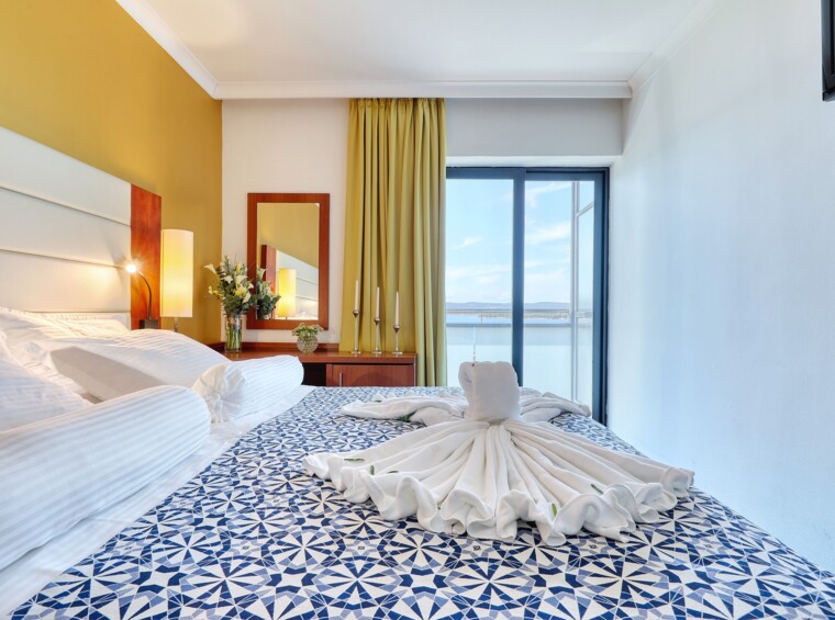 Letto matrimoniale con asciugamani decorativi in una camera d’albergo