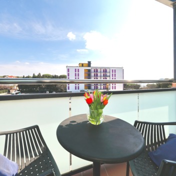 Balkon mit kleinem Tisch, Blumen und Blick auf die Umgebung