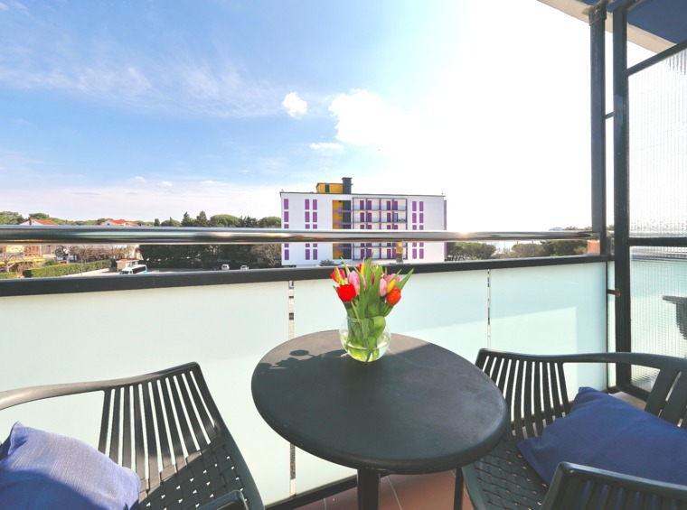 Balkon mit kleinem Tisch, Blumen und Blick auf die Umgebung
