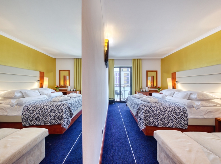 Hotelzimmer mit zwei Betten und mittigem Durchgang