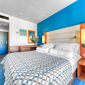 Hotelzimmer mit Doppelbett und blauer Wand