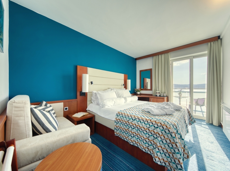 Camera d’albergo con letto matrimoniale e parete blu