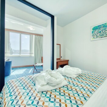 Schlafzimmer mit Doppelbett und dekorativ gefalteten Handtüchern