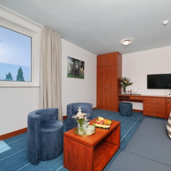 Wohnbereich mit Sofa, Fernseher und Couchtisch