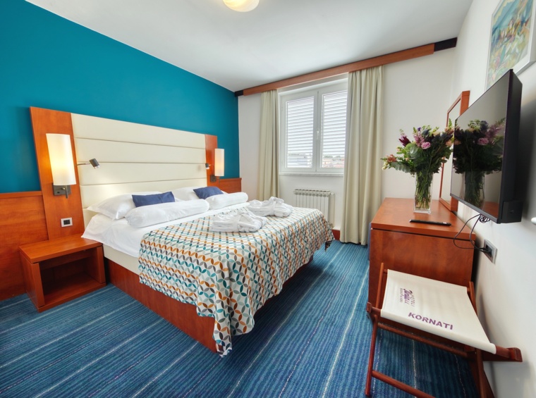 Comfortable bedroom with warm tones and a functional layout for a relaxing stay