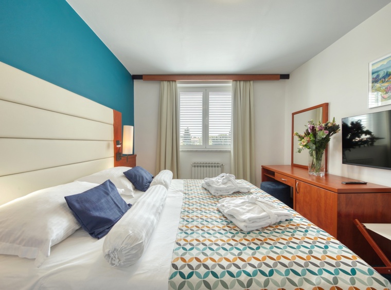 Modern bedroom with a double bed, pleasant colours and carefully selected details