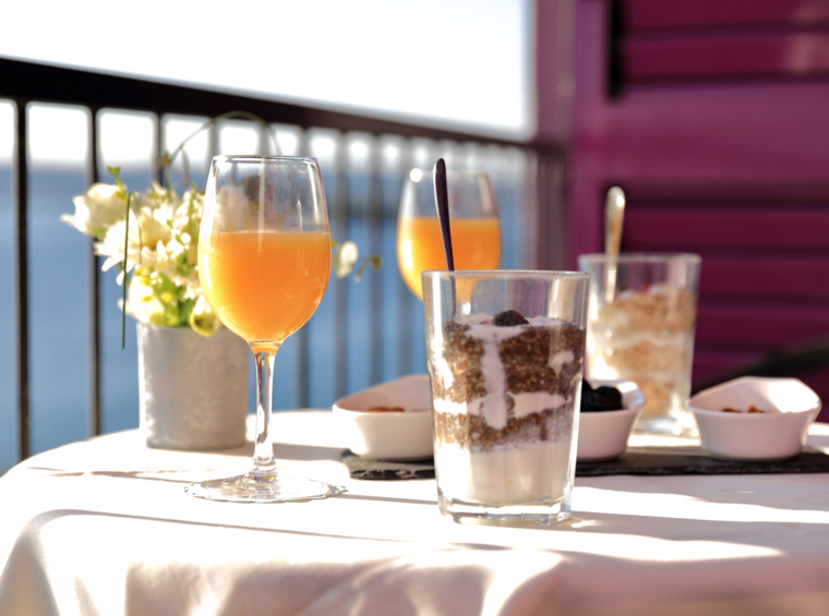 dessert e bevande serviti su un balcone con vista mare