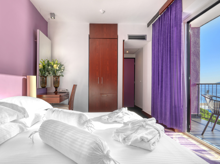 camera d’albergo moderna con letto matrimoniale e balcone vista mare