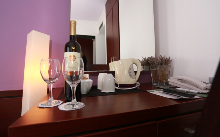 hotelski stol s vinom, čašama i kuhalom za vodu