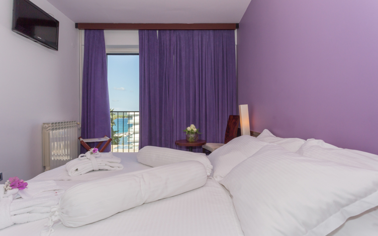 svijetla hotelska soba s bračnim krevetom i balkonom