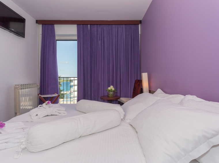 camera d’albergo luminosa con letto matrimoniale e balcone