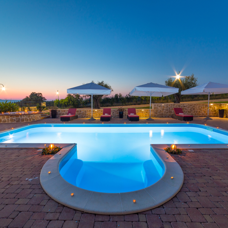 nachtansicht eines beleuchteten pools im villenhof