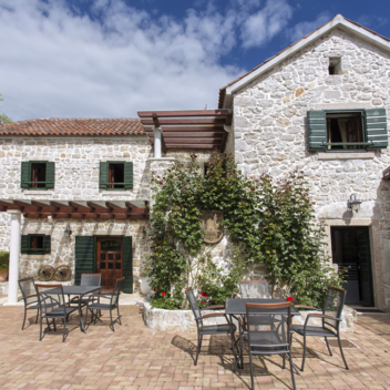 cortile in pietra della villa con terrazza e area salotto