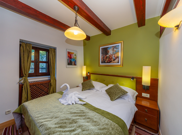 romantisches schlafzimmer mit doppelbett und holzbalken