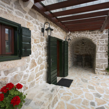 ingresso in pietra della casa con terrazza coperta