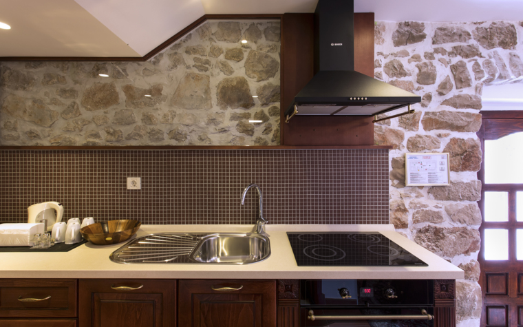 rustic kitchen with stone wall and modern appliances