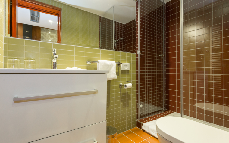 bathroom with shower, sink and toilet in warm tones
