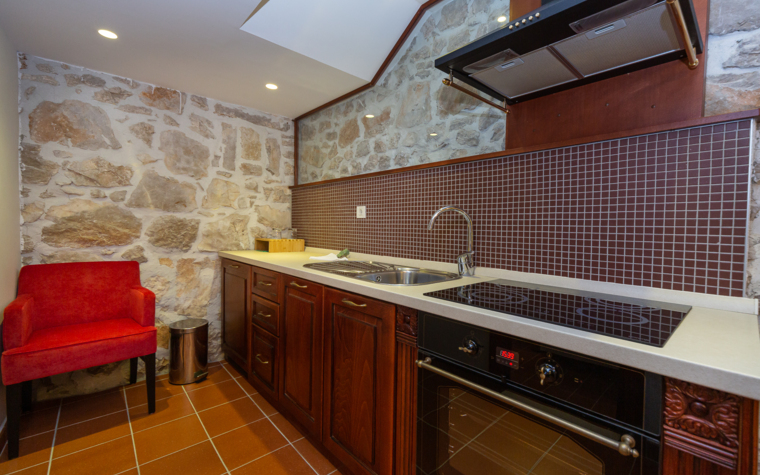 rustic kitchen with stone wall and modern stove