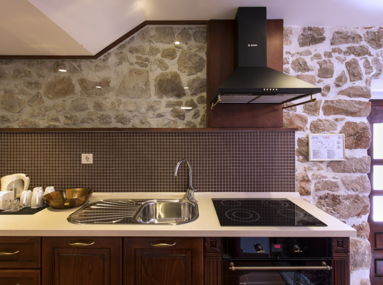 rustic kitchen with stone wall and modern appliances