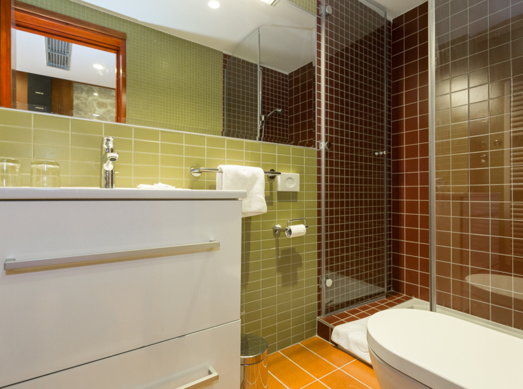bathroom with shower, sink and toilet in warm tones