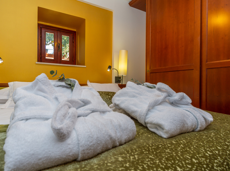 comfortable bedroom with double bed and bathrobes