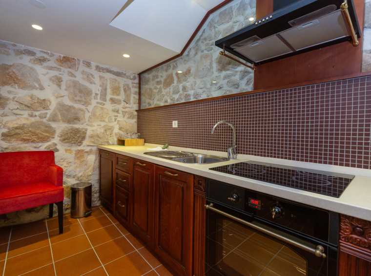 rustic kitchen with stone wall and modern stove