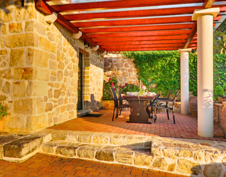 pokrita kamnita terasa z jedilno mizo