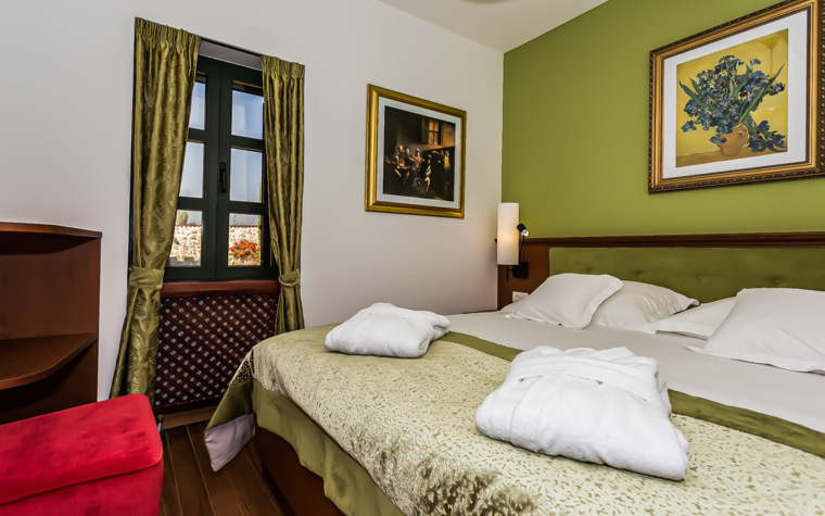 schlafzimmer mit doppelbett und bademänteln