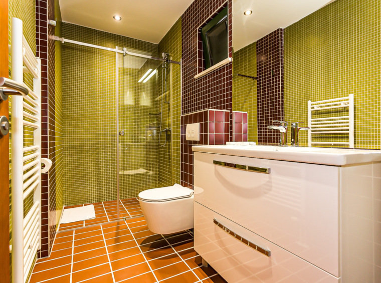 modernes badezimmer mit dusche und waschbecken in grünen und roten fliesen