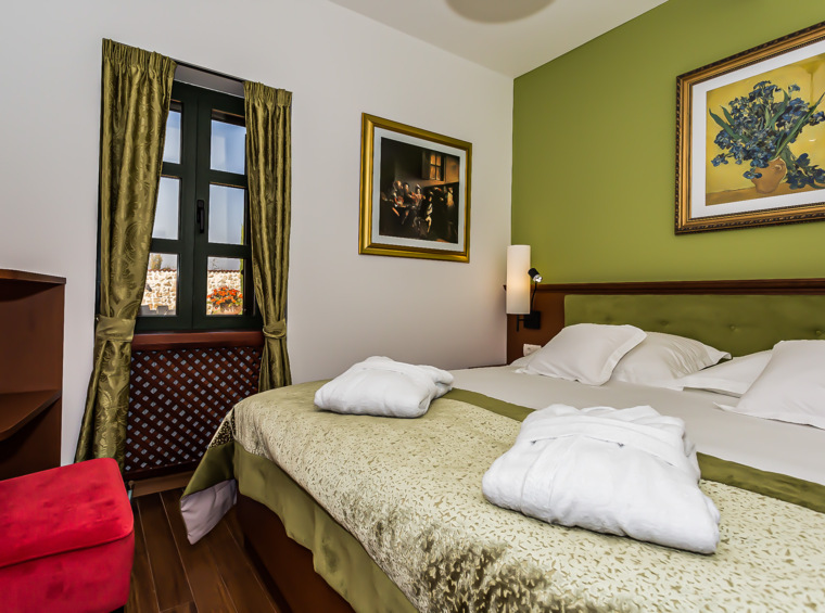 schlafzimmer mit doppelbett und bademänteln