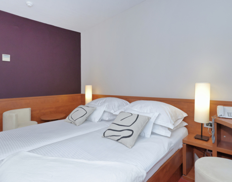 camera d’albergo con letto matrimoniale e comodini