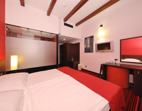 camera d’albergo moderna con letto matrimoniale e scrivania