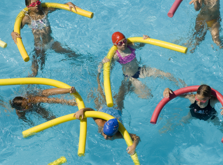 djeca na grupnom satu plivanja s plutajućim pomagalima