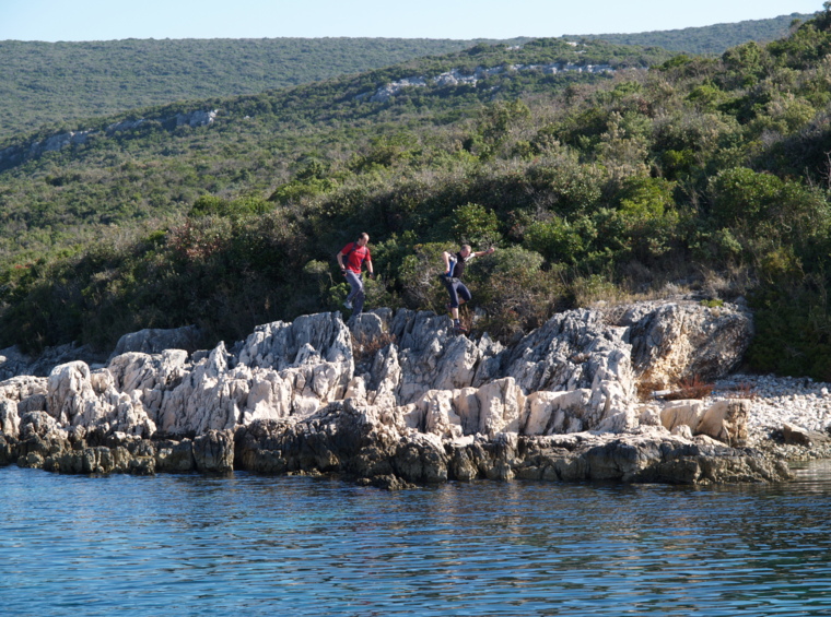 hikers on a rocky coastline by the sea