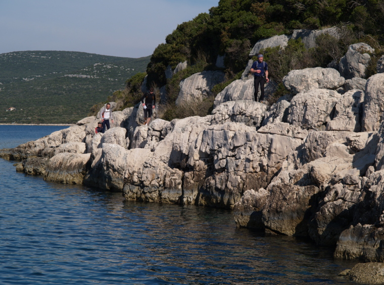 group of hikers on a rocky coast by the sea