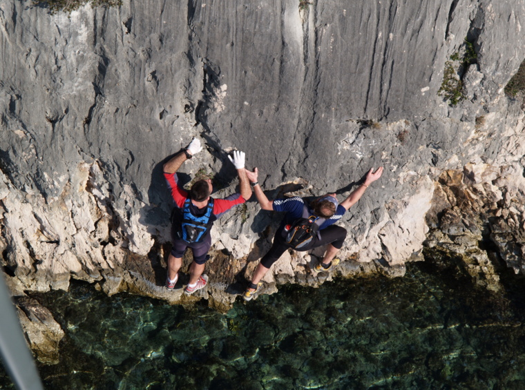 adventurers moving across rocks along the coast
