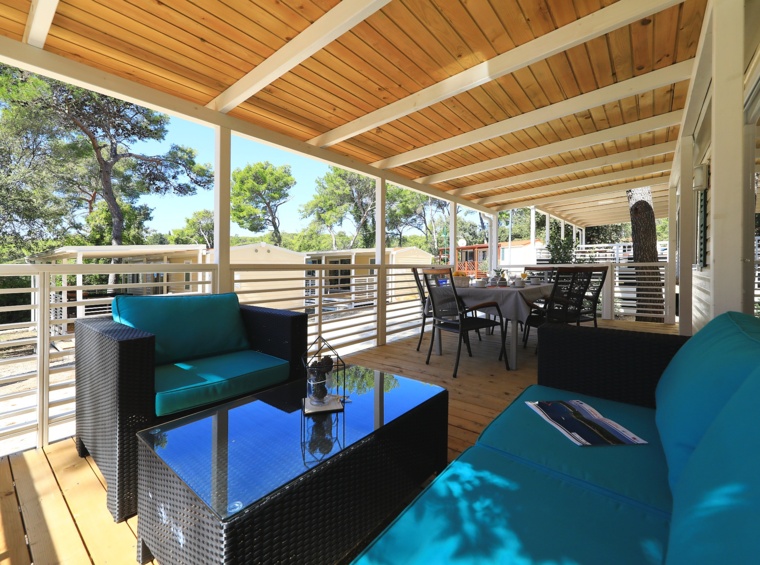 überdachte terrasse eines mobilheims mit sitzgruppe