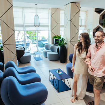 Un gruppo di persone visita l’interno di uno spazio alberghiero luminoso