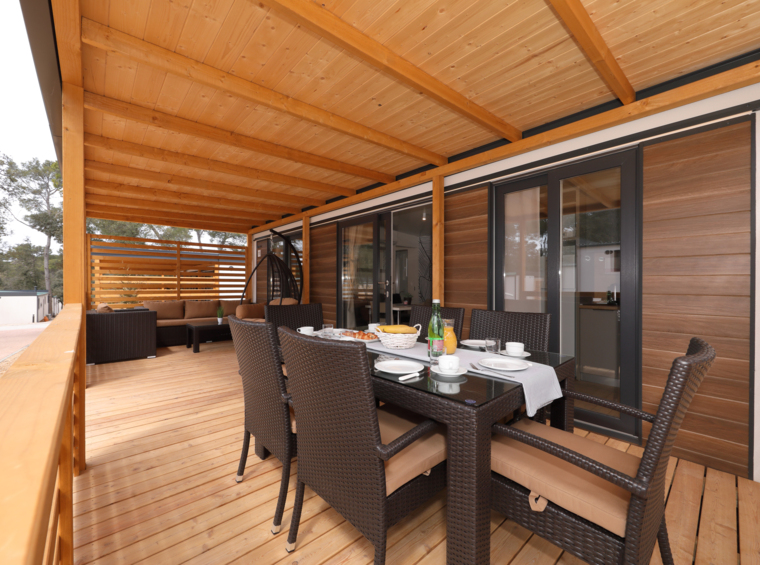 zona pranzo esterna sulla terrazza in legno coperta della casa mobile