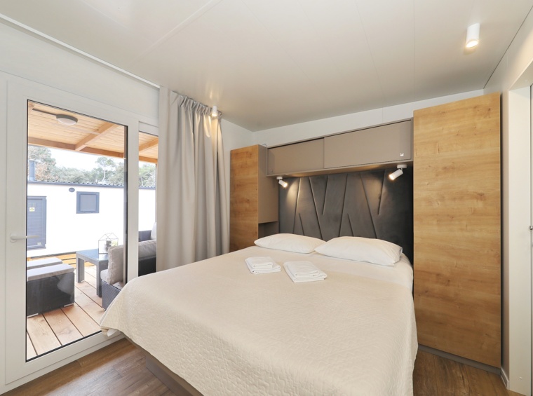 camera da letto in casa mobile con letto matrimoniale e accesso alla terrazza