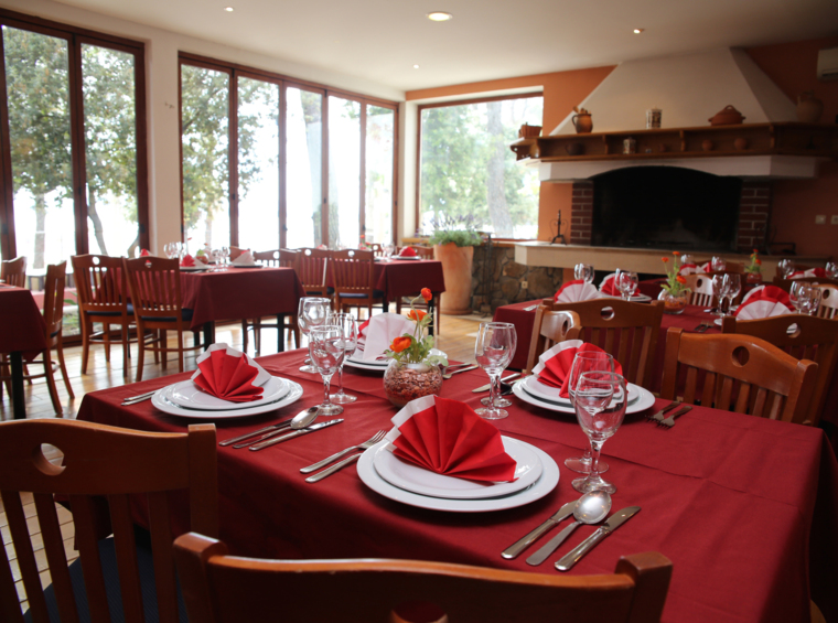 notranjost restavracije s pogrnjenimi mizami