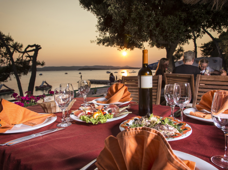 romantična večerja ob morju v restavraciji ob sončnem zahodu