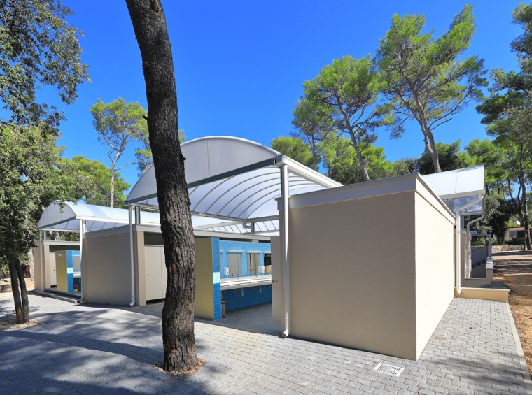 sanitarni objekt kampa, obdan z borovci