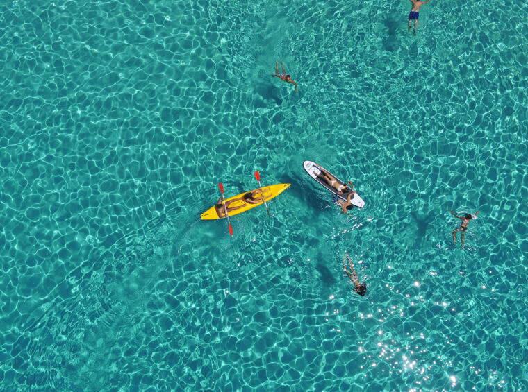 zračni pogled na plavalce in kajake v turkiznem morju