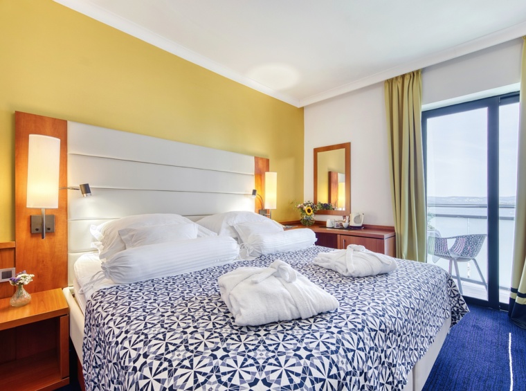 Hotelzimmer mit Doppelbett und Balkontüren