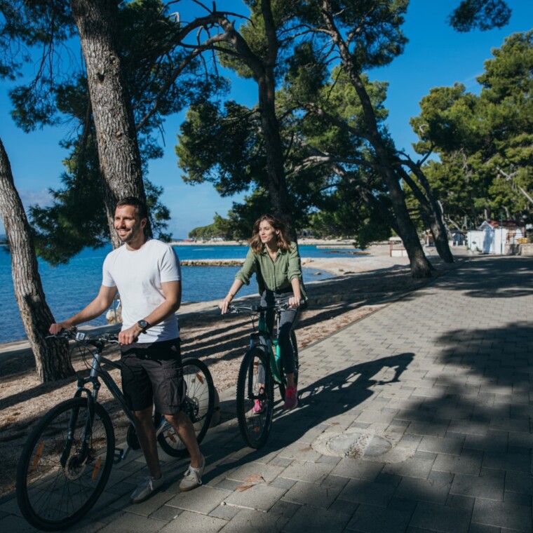 Couple cycling along the seaside promenade