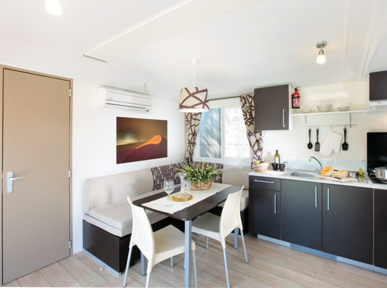 Dnevni boravak mobilne kućice s kuhinjom i blagovaonskim stolom