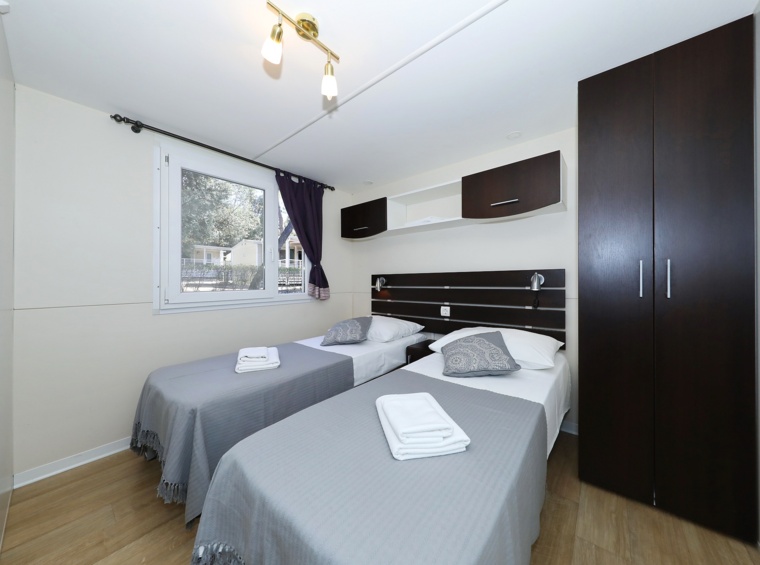 Spavaća soba mobilne kućice s dva odvojena kreveta